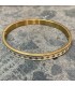 Bracelet en acier inoxydable doré et émail blanc orné de pois doré